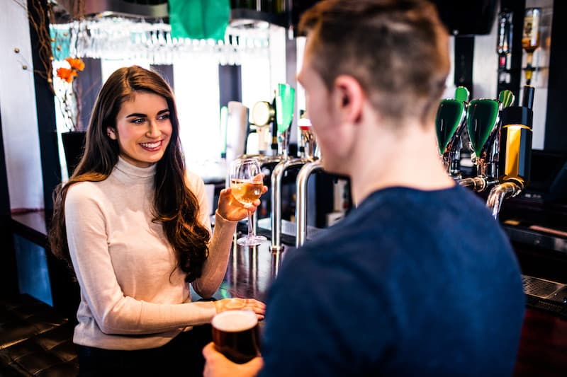 man approaching a woman at bar